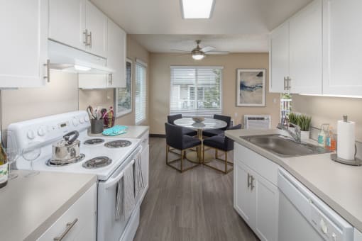 Kitchen with white appliances and a dining room with a table and chairs at Summerfield, OR, 97224