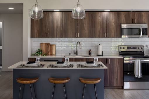A modern kitchen with a bar area and wooden cabinets.