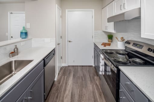 a kitchen with gray cabinets and white countertops
