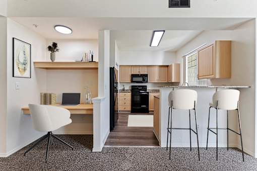 A kitchen with a desk and chair in the foreground.