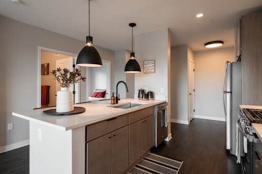 A modern kitchen with a white countertop and wooden cabinets.