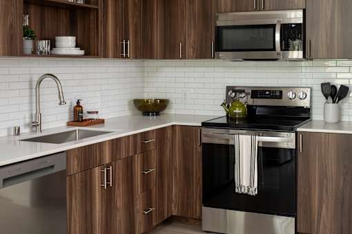 A modern kitchen with wooden cabinets and stainless steel appliances.
