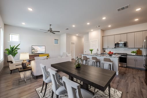 a living room and dining room with a table and chairs