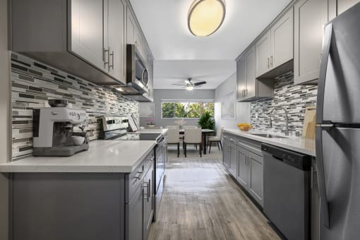 a kitchen with gray cabinets and white counter tops