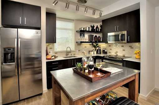 Kitchen with a stainless steel refrigerator and a wooden island at Annadel Downtown Santa Rosa apartments.