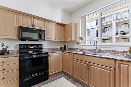 A kitchen with wooden cabinets and black appliances.
