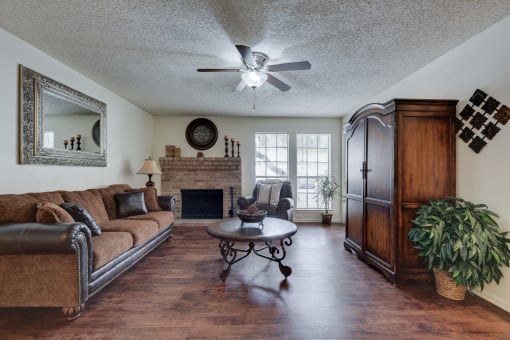 a living room with a fireplace and a ceiling fan