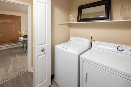 a white washer and dryer in a laundry room with a door to a