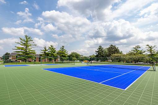 A tennis court with a blue surface and white lines.