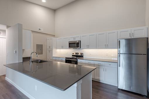 A modern kitchen with a large island and stainless steel appliances.