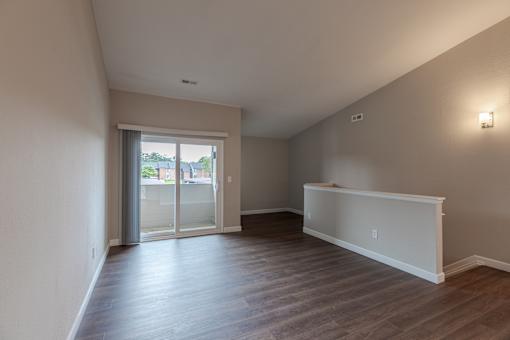 A room with a sliding glass door leading to a balcony.