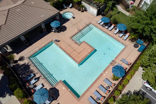 a large swimming pool with umbrellas and chairs around it