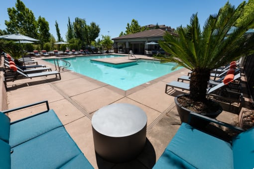 seating near expansive pool with surrounding lounge chairs and umbrellas