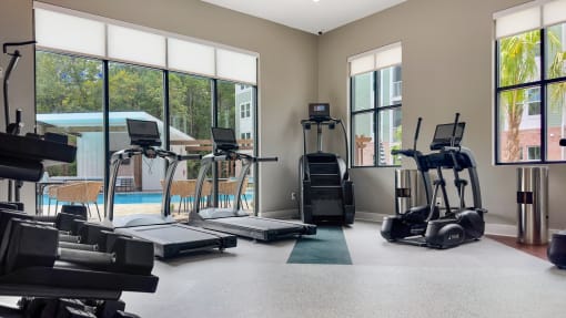 a gym with cardio machines and a swimming pool