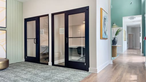 a hallway with black sliding glass doors and a rug