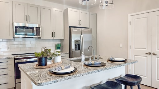 an open kitchen with a granite counter top and a sink
