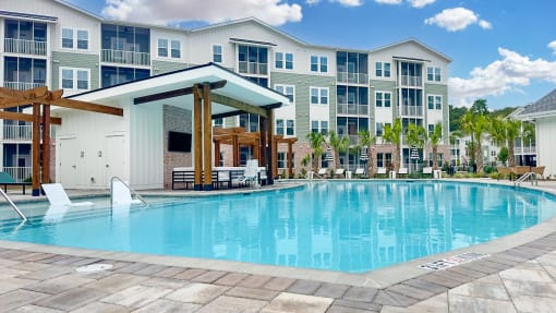 a swimming pool with an apartment building in the background