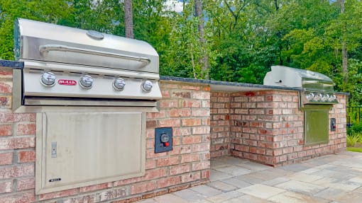 a barbecue grill in the corner of a brick wall