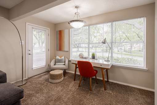 A room with a desk, chair, and window.