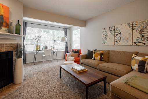A living room with a brown couch, a coffee table, and a fireplace.
