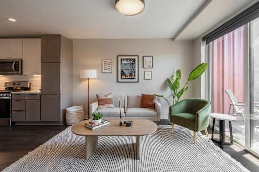 A modern living room with a green armchair and a grey sofa.