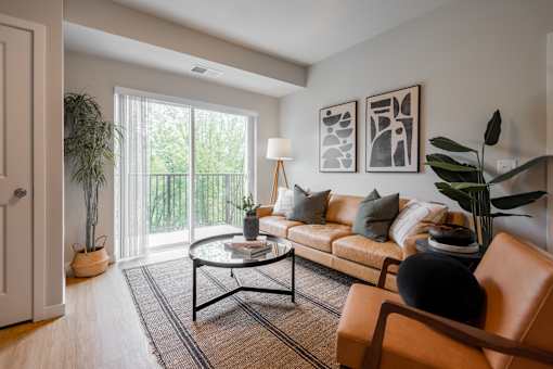 A living room with a brown leather chair and a glass coffee table.