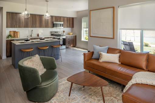 A modern living room with a green armchair and a brown leather couch.