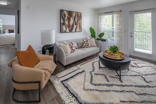 A living room with a couch, chair, and rug.