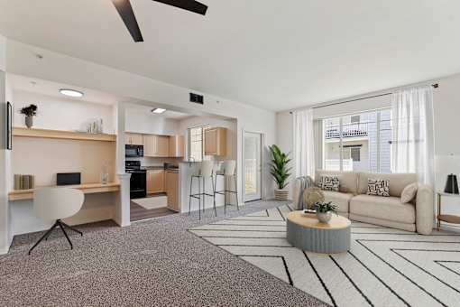 A modern living room with a grey carpet and a white ceiling fan.