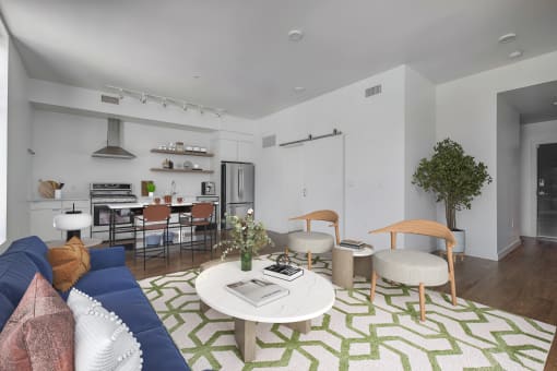 a living room with a blue couch and a green and white rug