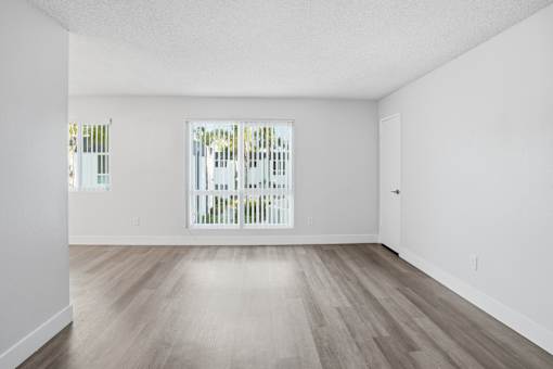 A room with a white wall and a wooden floor.