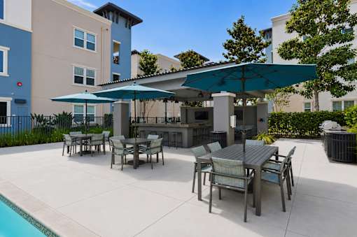 A patio with a table and chairs under a blue umbrella.