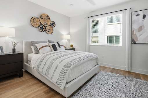 A bedroom with a large bed and a wooden floor.