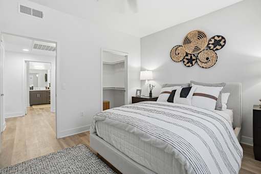 A bedroom with a large bed and a mirror on the wall.