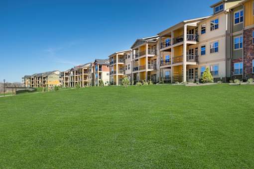 Apartment complex with green grass in front.
