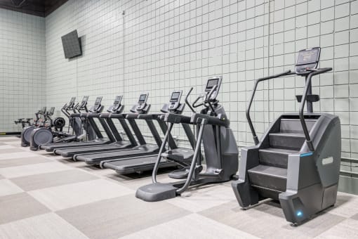 a row of cardio machines in a gym