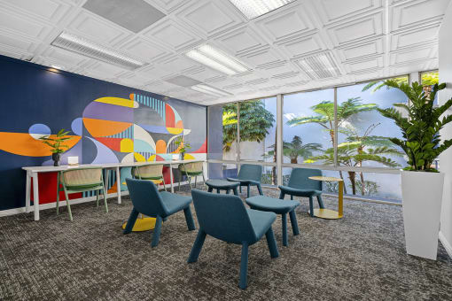 a dining room with blue chairs and a large wall mural