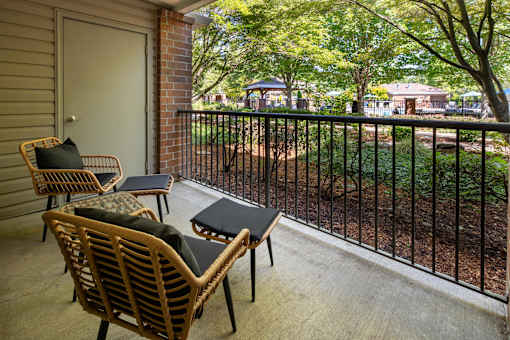 A patio with a table and chairs overlooking a yard.