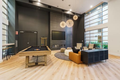 a living room with a pool table and a tv