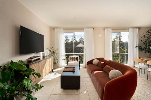 A living room with a red couch and a flat screen TV.