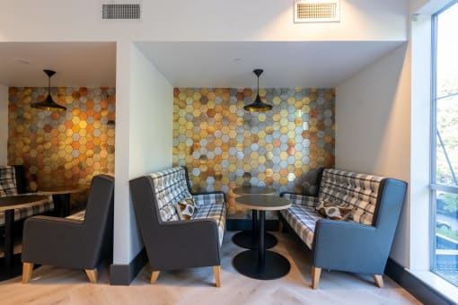 a living room with couches and chairs and a wall with geometric tiles