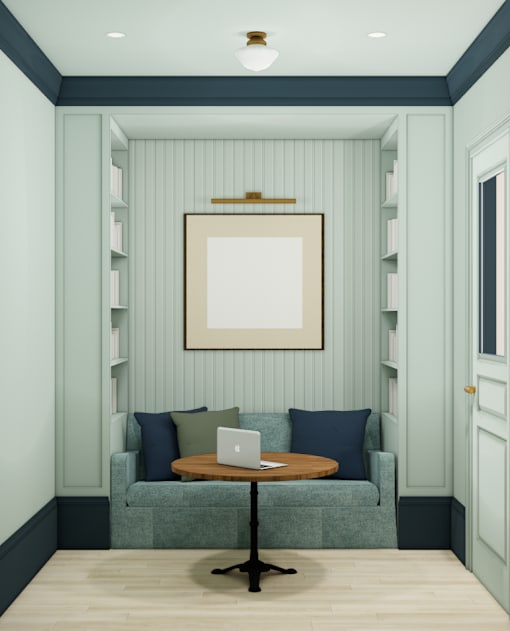 A room with a green couch and a laptop on a table.
