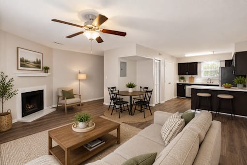 A living room with a fireplace, a dining table, and a kitchen area in the background.