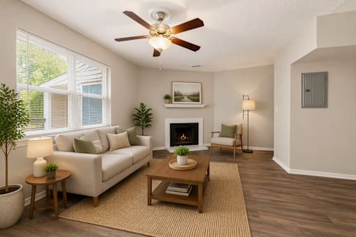 A living room with a fireplace, couch, and potted plant.