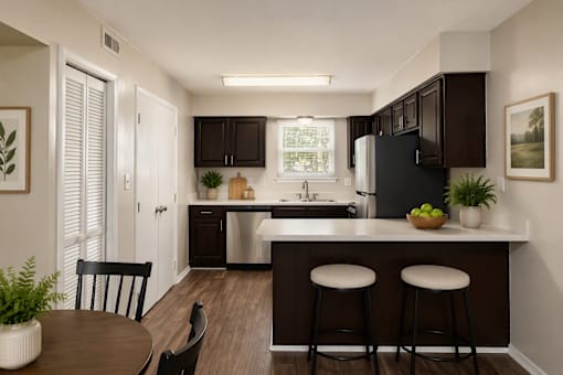 A kitchen with a black refrigerator and brown cabinets.