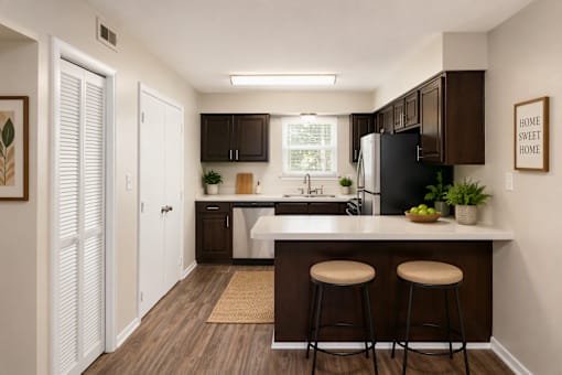 A kitchen with a white door and a black fridge.