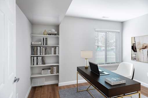 A room with a desk, chair, and bookshelf.