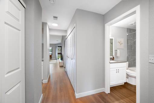 A white bathroom with a wooden floor and white walls.