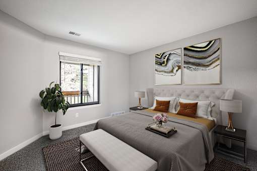 A bedroom with a large bed and a potted plant.