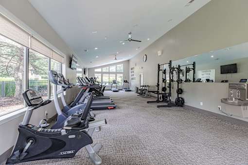 A gym with treadmills, elliptical machines, and weightlifting equipment.